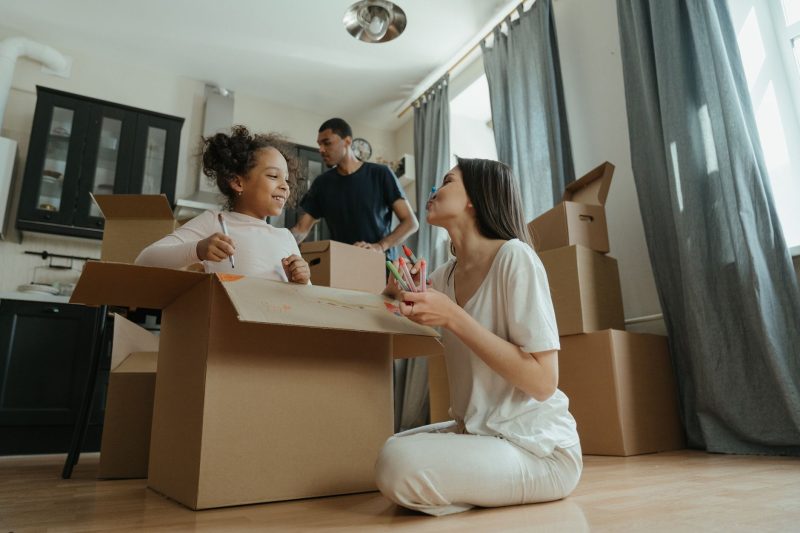 Home 14 A joyful family unpacking boxes while moving into their new 1793120483
